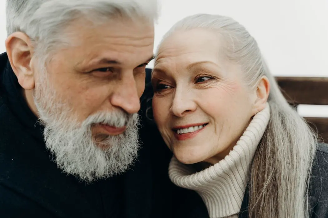 Pareja de adultos mayores sonriendo, abrazados
