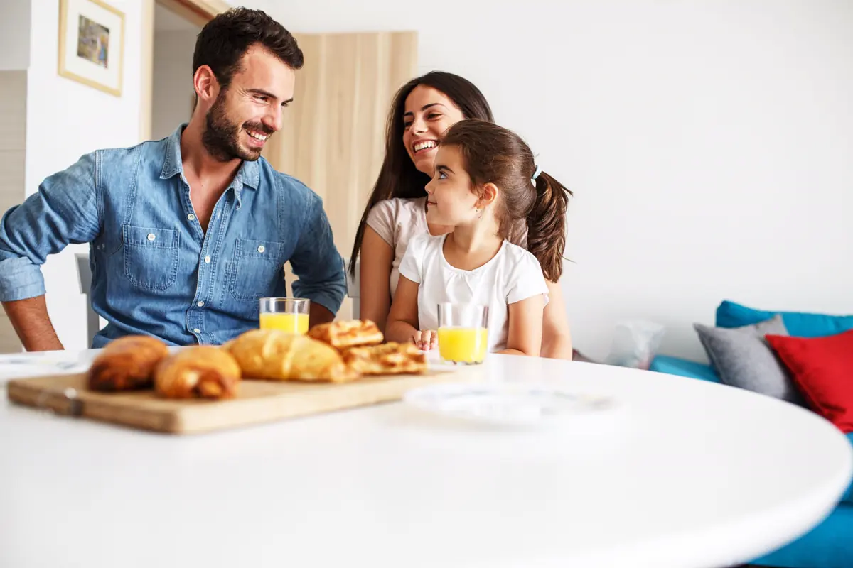 Familia desayunando junta en la mesa de su casa